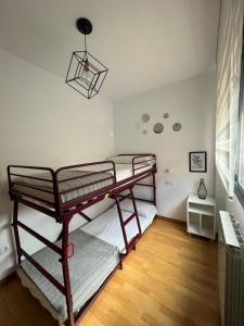 1 dormitorio con 2 literas y lámpara en Llano Santa Isabel, en Zaragoza