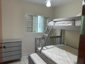 een kamer met 2 stapelbedden en een dressoir bij Apartamento Bem Localizado in Serra Negra