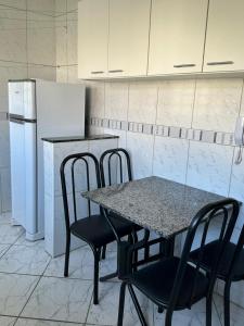 een keuken met een tafel en stoelen en een koelkast bij Apartamento Bem Localizado in Serra Negra