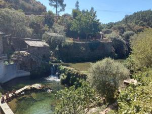 Blick auf einen Fluss mit Menschen im Wasser in der Unterkunft Retiro da Serra in Penhas da Saúde