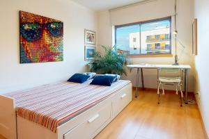 a bedroom with a bed and a desk in it at Sunny Flat Lisbon Oeiras in Quejas