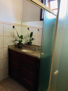 a bathroom with a sink and a mirror at Casa 300 m Praia Jabaquara in Paraty