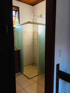a shower with a glass door in a bathroom at Casa 300 m Praia Jabaquara in Paraty