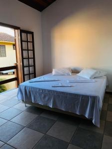 a bedroom with a bed with a blue blanket at Casa 300 m Praia Jabaquara in Paraty