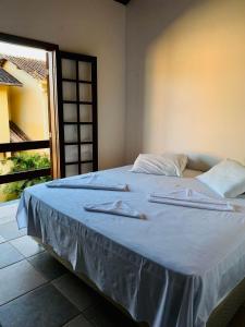 a bed in a room with two towels on it at Casa 300 m Praia Jabaquara in Paraty