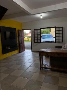 a living room with a view of a car through a window at Casa 300 m Praia Jabaquara in Paraty