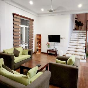 uma sala de estar com sofás e uma televisão de ecrã plano em The Paddy em Kottawa