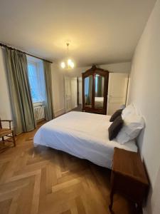 una camera con letto bianco e pavimento in legno di Villa 18.78, 10 min de la Suisse a Damprichard