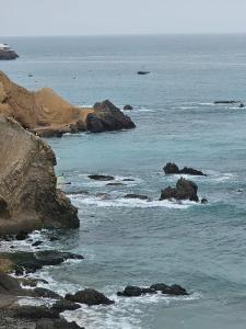 una vista del océano con rocas en el agua en Departamento de Playa San Bartolo Ocean Reef - SOL, ARENA Y MAR, en San Bartolo