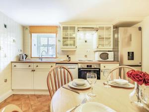 a kitchen with a table and two chairs and a kitchen with white cabinets at 3 Bed in Blanchland CN110 