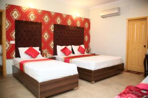 מיטה או מיטות בחדר ב-Doves Inn Hotel, Tipu Block, Feroze Pur Road, kalma Chowk