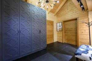 a room with wooden walls and a closet with gray doors at Pillow House Montibus in Pribylina +89 photos