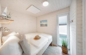 1 dormitorio con 1 cama con sombrero en Hausboot Rán mit Dachterrasse in Kragenæs auf Lolland/DK en Torrig