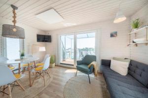 sala de estar con sofá azul y mesa en Hausboot Rán mit Dachterrasse in Kragenæs auf Lolland/DK, en Torrig