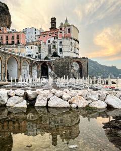 a building with a reflection in a body of water at Amalfi Antica in Atrani