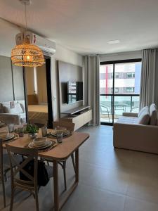 a living room with a table and a couch at Edificio Liv P.Verde Apto 906-Mandi Hospitalidade in Maceió