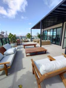 a patio with benches and tables on a building at Edificio Liv P.Verde Apto 906-Mandi Hospitalidade in Maceió