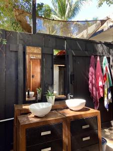 baño con 2 lavabos en una encimera de madera en Maracuyá Hostal Zipolite - Coworking Space, en Zipolite