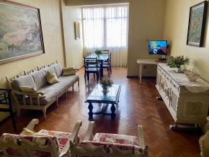 uma sala de estar com um sofá e uma mesa em São Salvador, Flamengo, 3 quartos no Rio de Janeiro