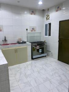 an empty kitchen with a stove and a sink at الريان للنزل الخضراء 
