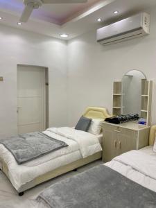 a bedroom with two beds and a mirror and a fan at الريان للنزل الخضراء 