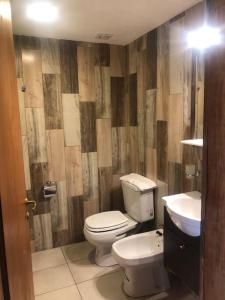 a bathroom with a toilet and a sink at Del Paralelo 2 in El Bolsón