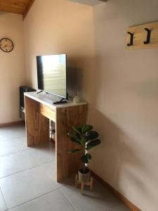 a desk with a monitor and a plant in a room at Del Paralelo 2 in El Bolsón