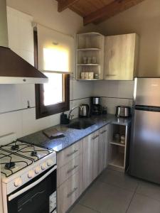 a kitchen with a sink and a stainless steel refrigerator at Del Paralelo 2 in El Bolsón