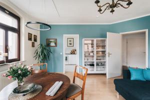 een woonkamer met een houten tafel en blauwe muren bij Apartment Maria Luisa in Dresden