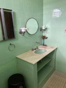 uma casa de banho com um lavatório e um espelho em São Salvador, Flamengo, 3 quartos no Rio de Janeiro