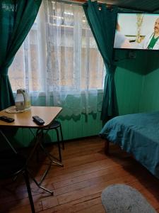 um quarto com uma cama, uma mesa e uma televisão em Habitación cómoda por día em Valdivia
