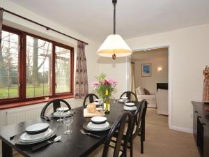a dining room with a black table and chairs at 4 Bed in Sherborne OOMEO in Chetnole