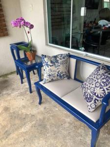 two blue chairs with pillows sitting next to a window at Casa de Praia in Cananéia