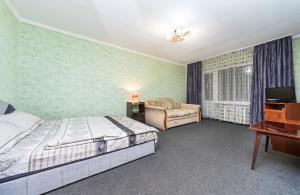 um quarto com uma cama, uma cadeira e uma secretária em Уютная однокомнатная квартира возле м.Печерская em Kiev