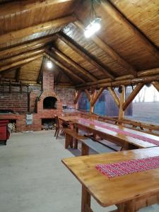 una fila di tavoli in legno in un edificio con forno in mattoni di Cabana Bradu Moșului 
