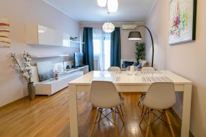 Trendy apartment 5 min to city centre!` في زغرب: مطبخ وغرفة معيشة مع طاولة وكراسي