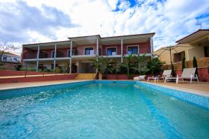 a house with a swimming pool in front of a house at Samari Afitos in Afitos