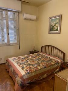 a bedroom with a bed with a quilt on it at São Salvador, Flamengo, 3 quartos in Rio de Janeiro