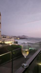 a glass of white wine sitting on a table at Departamento de Playa San Bartolo Ocean Reef - SOL, ARENA Y MAR in San Bartolo