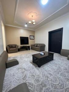 a large living room with couches and a television at منازل الرؤية الفندقية in Najran