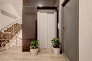 um corredor com dois vasos de plantas em frente a uma porta em Townhouse Siri Residency em Bangalore