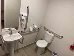 La salle de bains est pourvue de toilettes blanches et d'un lavabo. dans l'établissement Front Comfort Teófilo Otoni, à Teófilo Otoni