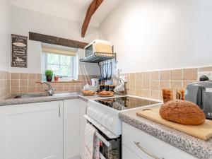 a kitchen with a counter with a bread on a cutting board at 1 Bed in Crackington Haven HAWTH in Saint Gennys