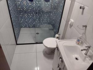 a bathroom with a shower and a toilet and a sink at 100 m da praia elevador garagem e portao automático in Mongaguá