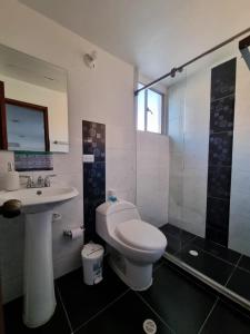 a bathroom with a toilet and a sink and a shower at Florentina in Tunja