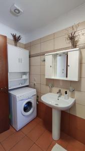 y baño con lavadora y lavamanos. en Sandra Apartment, en Katokhórion