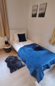 a bedroom with a bed and a blue blanket at Fine Living - Einzeln oder größere Gruppen- 5 Zimmer je mit eigenem Bad - Küche - Aufenthaltsraum - bis 8 Personen in Meine
