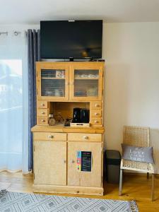 un centro de entretenimiento de madera con TV de pantalla plana en la parte superior en The Dolomiti View, en Debant