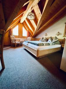 ein Schlafzimmer mit einem großen Bett in einer Holzdecke in der Unterkunft Sporthotel Oberwald in Oberwald