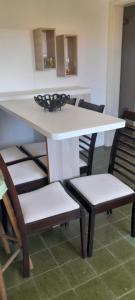 a white table and chairs with a white table and chairsskirts at Residencial Brilha Mar in Capão da Canoa